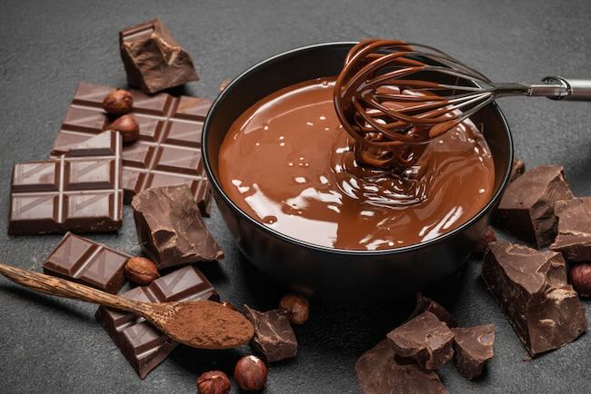bowl of melted chocolate with chocolate around it