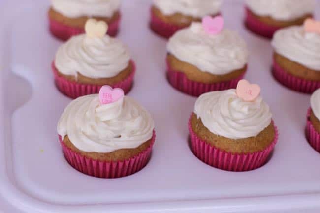 adding valentines sprinkles to muffins