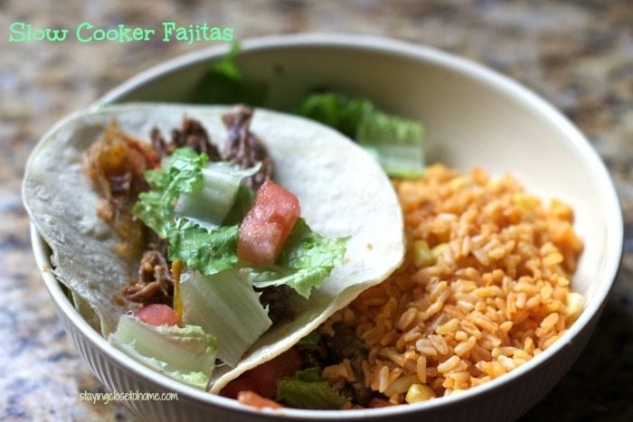 slow cooker fajitas in a tortilla in a bowl with mexican rice