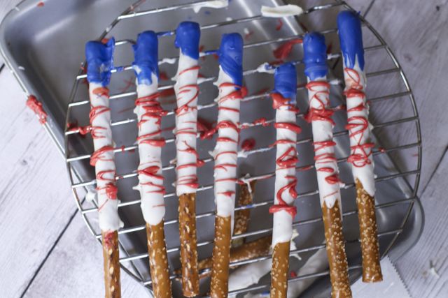 patriotic food ideas like these chocolate covered flag pretzels are ideal for fourth of july parties. 