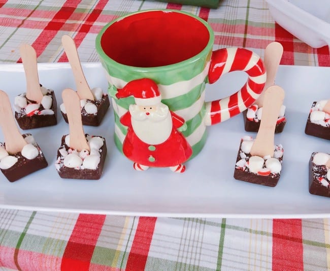 Homemade Hot Cocoa Cubes on a white platter with santa claus mug
