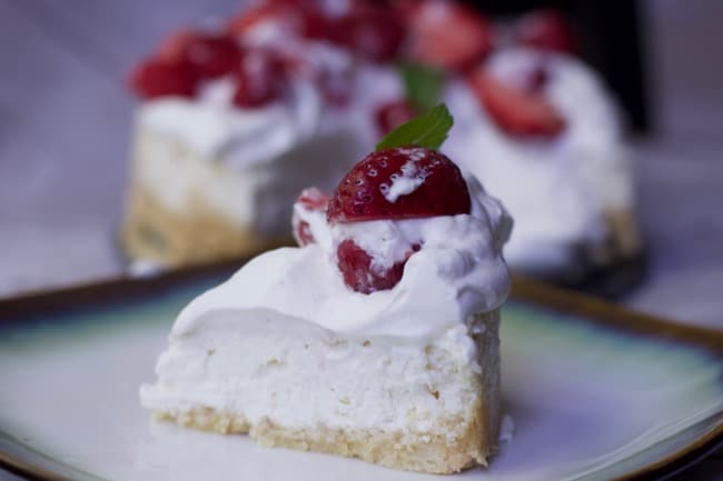 slice Keto Diet Cheesecake with strawberries and whipped cream on a plate