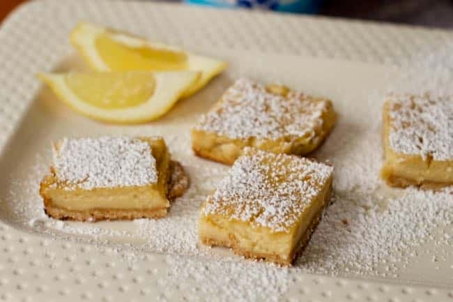 close up Yogurt lemon bars on tray with lemon on side